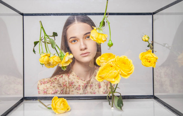 Female model behind glass box with flowers - Zdjęcie, obraz