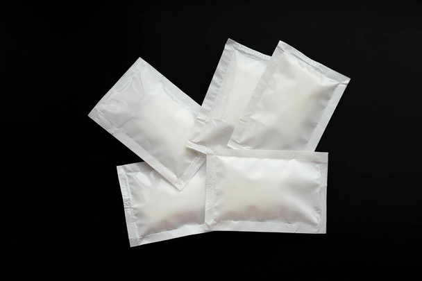 Blank white sachet packets stack mockup isolated on black background. Empty airtight pack mock-up for sauce, coffee, wet wipe, mayonnaise. - Foto, imagen