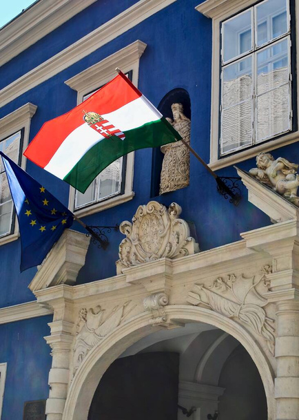 Sopron, Hongrie : drapeau tricolore de la Hongrie (Magyarorszg zszlaja) et drapeau de l'Union européenne. Bâtiment bleu est le Palais Esterhzy à la fois le Musée central des mines et le Musée des forêts.  - Photo, image