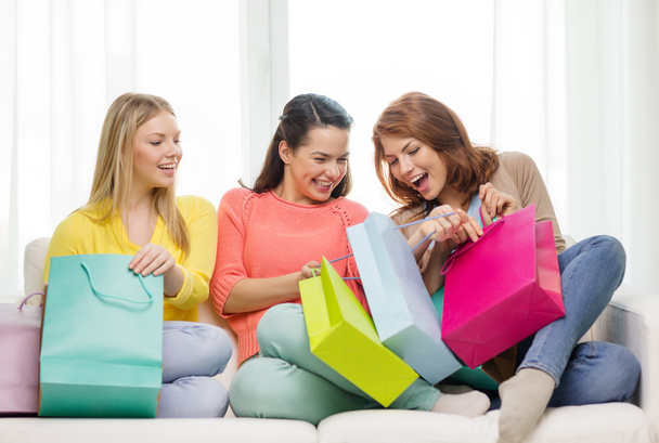 smiling teenage girls with many shopping bags - 写真・画像