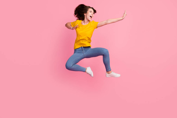Photo of impressed funny young woman dressed yellow t-shirt jumping high practicing yoga isolated pink color background - Fotó, kép