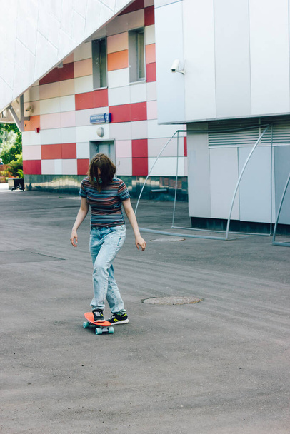 Portrait pleine longueur de femme souriante heureuse avec un look à la mode réjouissez-vous en patinant sur penny board pendant le week-end d'été, joyeux skateboarder féminin chevauchant sur penny board s'amuser - Photo, image