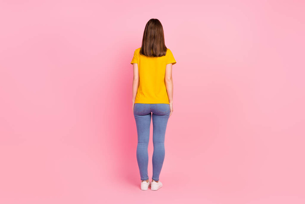 Full size photo of back brunette hair young lady stand wear jeans t-shirt isolated on pink color background - Fotografie, Obrázek