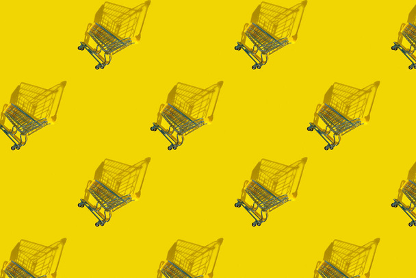 Shopping carts background with shadows, sale, yellow background. Purchase. Flat lay - Foto, afbeelding
