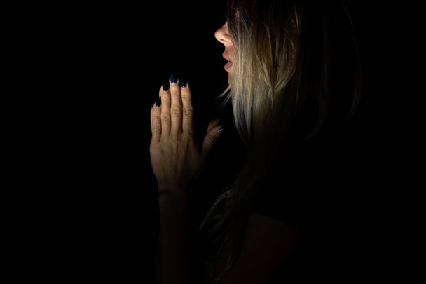 fiatal lány imádkozik Istenhez a sötétben, fiatal lány a sötétben, vallás és az emberek, ima - Fotó, kép