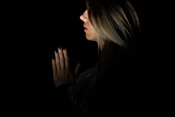 νεαρή κοπέλα προσεύχεται στο Θεό στο σκοτάδι, νεαρή κοπέλα στο σκοτάδι, θρησκεία και άνθρωποι, προσευχή - Φωτογραφία, εικόνα