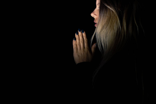 Genç kız karanlıkta Tanrı 'ya dua ediyor, karanlıkta genç kız, din ve insanlar, dua. - Fotoğraf, Görsel
