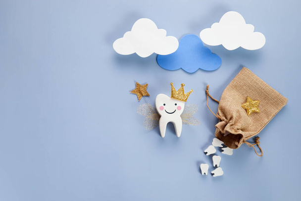 National Tooth Fairy Day. Children tooth fairy. Cute tooth with wings, a crown and a magic wand and bag with teeth. - Фото, зображення