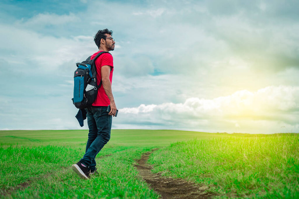 Adventurous man in the field, man with backpack in the field looking - Photo, Image