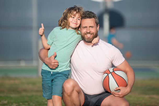 χαρούμενος πατέρας και γιος παίζουν μπάσκετ με μπάλα εξωτερική, πατρότητα - Φωτογραφία, εικόνα