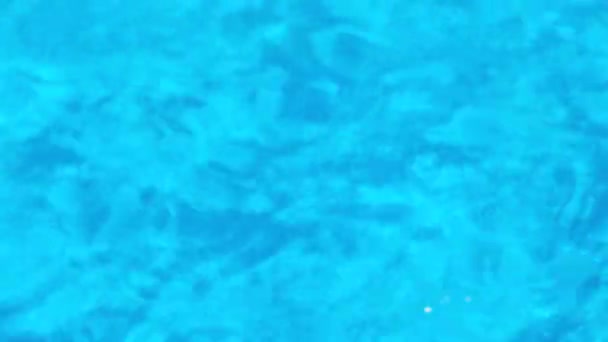 Tiszta átlátszó kék víz a medencében fényvisszaverődéssel. 4k felbontású videó. A víz szerkezete az úszómedencében. - Felvétel, videó