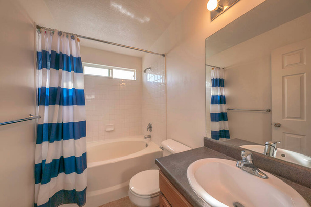 Interieur van een badkamer met douche bad set en rechthoekig schuifraam - Foto, afbeelding