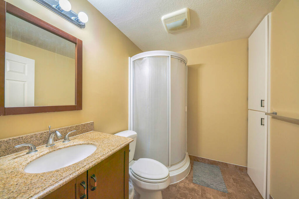 Интерьер ванной комнаты с желтыми стенами и круглым душем - Фото, изображение