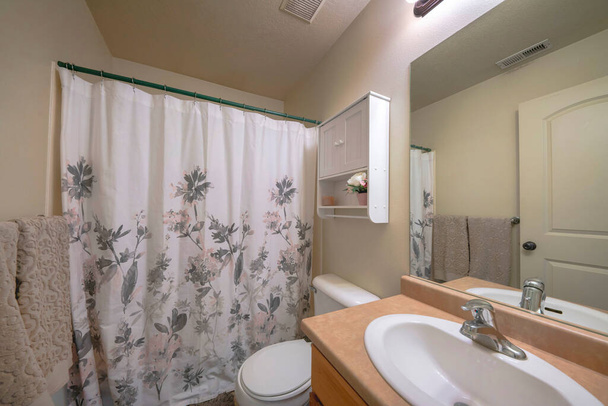 Małe wnętrze łazienki z dekoracyjnym nadrukiem szarej zasłony prysznicowej kwiatowy - Zdjęcie, obraz