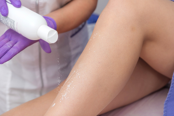 Procedimiento cosmético aplicando talco en las piernas depilación depilación depilación frotamiento talco ablandamiento de la piel - Foto, imagen