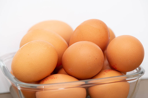 Поднос с коричневыми и органическими куриными яйцами на столе. - Фото, изображение