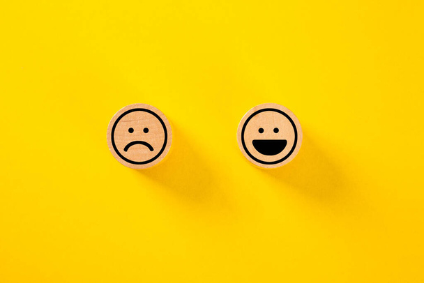 Kunden wählen Smiley-Gesicht und trauriges Gesichtssymbol auf Holzwürfel, Service-Bewertung, Zufriedenheitskonzept, Service-Bewertung, Zufriedenheitskonzept. - Foto, Bild