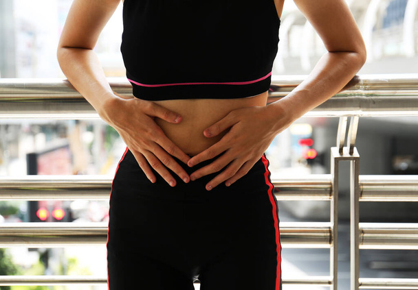 Athlètes féminines, douleurs abdominales, règles pendant l'exercice dans la rue à pied dans la ville
. - Photo, image