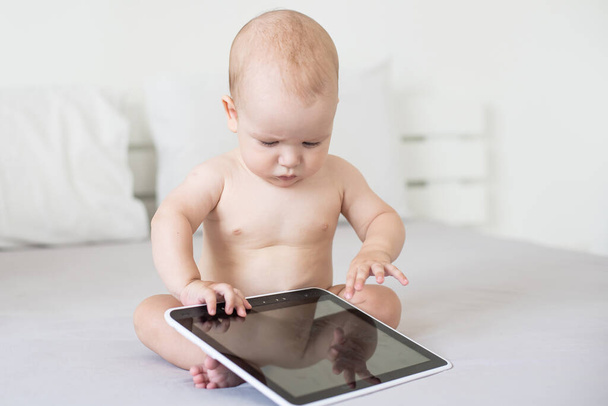 Tablet bilgisayarlı altı aylık bir bebek, evde, ekranlara bakıyor. - Fotoğraf, Görsel