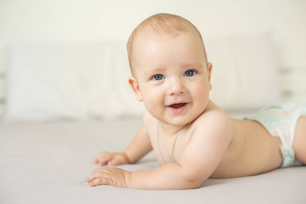Portrait of a crawling baby on the bed in her room - Photo, Image
