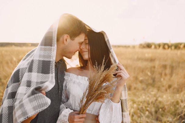 Happy couple in love in wheat field at sunset - Foto, afbeelding