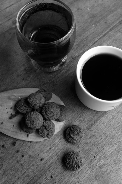 Photo of dry chocolate cake and a cup of coffee on a wooden table - Photo, Image