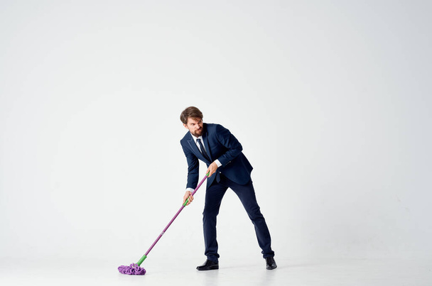 бізнесмен у костюмі миє підлогу мопедом
 - Фото, зображення