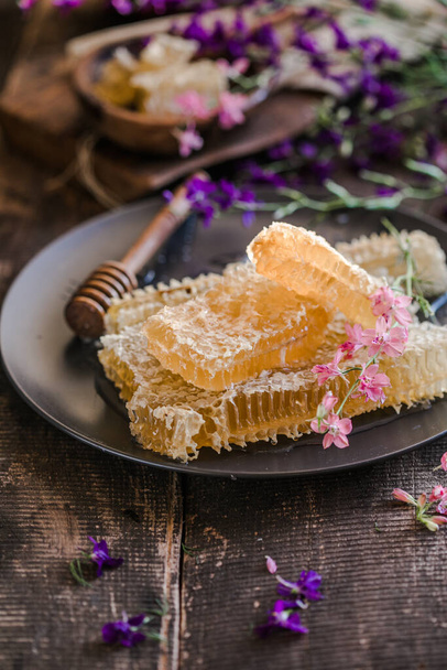 wooden honey dipper and honeycombs on background of wooden - Foto, afbeelding