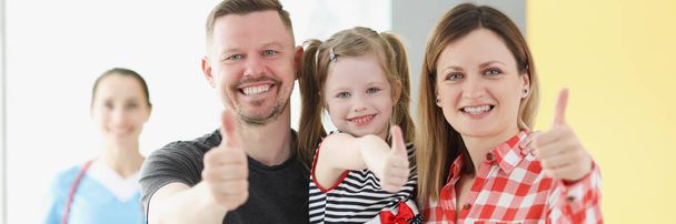 Lächelnde Familie mit Daumen-hoch-Geste im Hintergrund ist Arzt - Foto, Bild