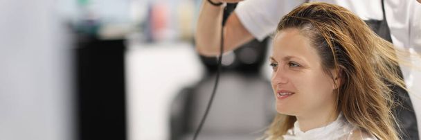 Master kapper droogt haar met haardroger om aclient in schoonheidssalon - Foto, afbeelding