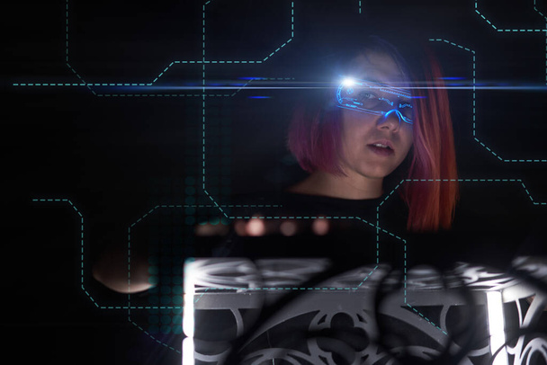 Mooie vrouw in cyber futuristische stijl met behulp van een nieuwe technologie om toegang te krijgen tot het netwerk. - Foto, afbeelding