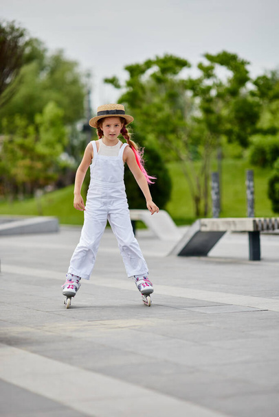 Cute little child girl on roller skates at park - Foto, Imagem