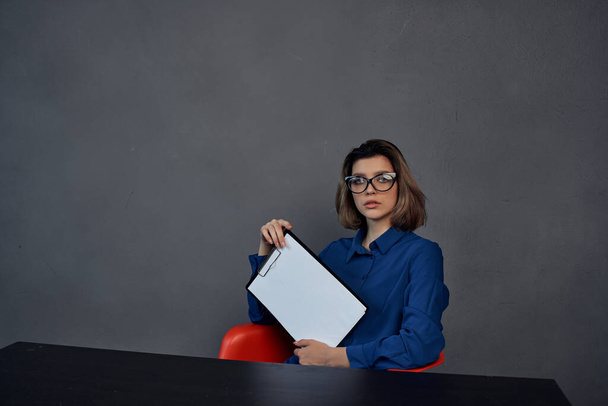 Nainen sininen paita istuu pöydässä kansio käsissä Kopioi tilaa - Valokuva, kuva
