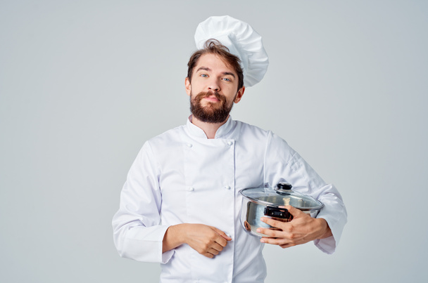 мужчина шеф-повар с кастрюлей в руках, готовящий еду кухня стиль жизни - Фото, изображение