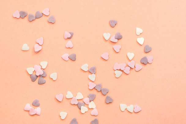 öntözés édességek formájában szív fehér, lila és rózsaszín színekben - Fotó, kép