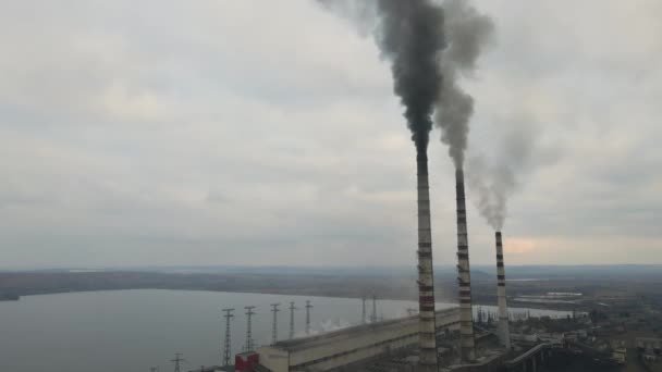 Uitzicht vanuit de lucht op hoge pijpen van kolencentrales met zwarte rook die de vervuilende atmosfeer opgaat. - Video