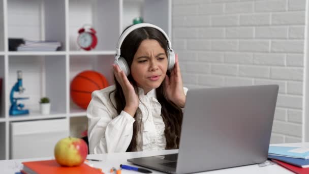 boldog gyermek fülhallgató tanulni az iskolában online lecke laptop mutatja hüvelykujj fel, oktatás - Felvétel, videó