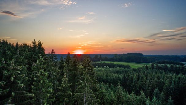 The sunset over the forest and agricultural fields in the morning - Фото, изображение