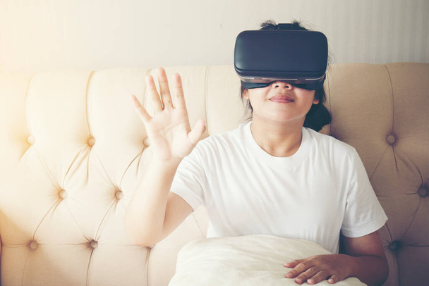 Asyalı kız VR gözlük takıyor ve İndoo 'nun tadını çıkarıyor. - Fotoğraf, Görsel