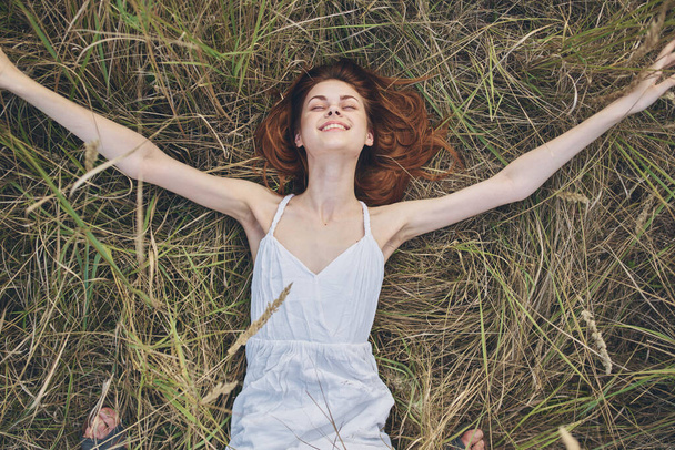 vrolijke vrouw ligt op het gras rust levensstijl natuur - Foto, afbeelding