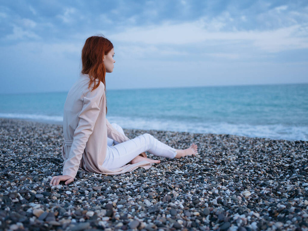 Женщина, сидящая у океана в вечернем романе - Фото, изображение