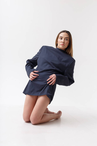 giovane attraente donna asiatica in abito blu in piedi sulle ginocchia in studio - Foto, immagini