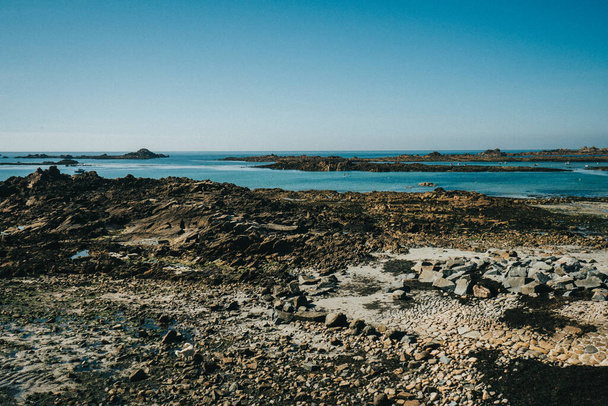 Ein schöner Blick auf die Felsen und die Steine in Küstennähe an einem sonnigen Sommertag - Foto, Bild
