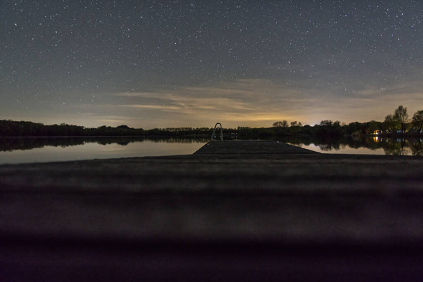 A mesmerizing view of the starry sky over the Oberrieder Weiher, Bayern, Germany at night - Foto, immagini