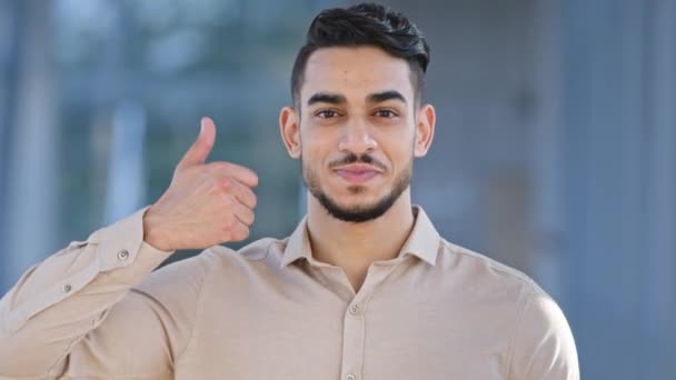 Mužský portrét šťastný spokojený nadšený úsměv zubatý hispánský muž podnikatel při pohledu na kamery ukazuje, jako dává palec nahoru podporuje schvaluje doporučuje zubní centrum služby dělá vynikající gesto - Záběry, video