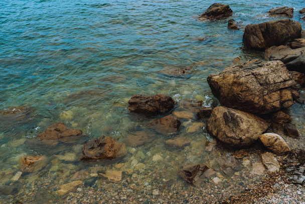 A felső nézet közelkép kövek és sziklák közelében az óceán egy napos nyári napon - Fotó, kép