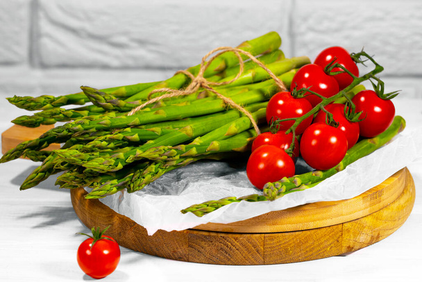 Spargel und Tomate. Frische Ernte, traditionelle italienische Küche und Lebensmittel. Gesunde vegetarische Kost. Frisches rohes Bio-Gemüse, Markt. Veganer Hintergrund - Foto, Bild