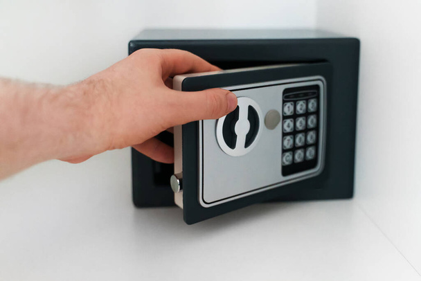 Man's hand opening small safe. - Photo, Image