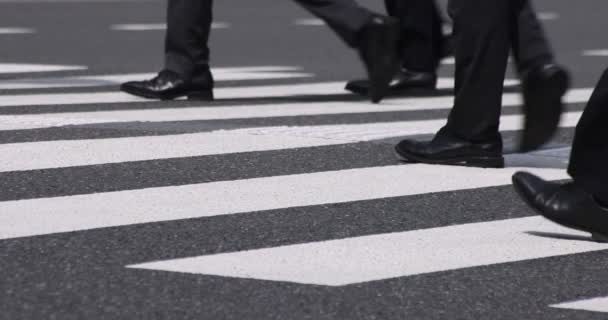Um movimento lento de partes do corpo de pessoas ambulantes no cruzamento na cidade de negócios - Filmagem, Vídeo