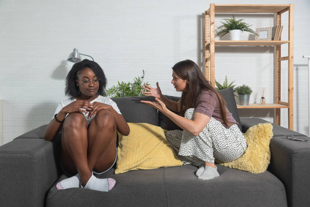 Two young college lesbian mixed race couple in relationship African black and caucasian women argue in their home about spending money for rent - Photo, Image